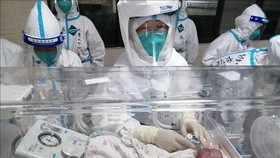 Nhân viên y tế chăm sóc em bé sơ sinh tại bệnh viện ở Thụy Lệ, tỉnh Vân Nam, Trung Quốc, ngày 11-8-2021. Ảnh minh họa: THX
