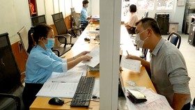 Người dân làm thủ tục hành chính tại phường 6 (quận 3) - phường sẽ được sáp nhập với phường 7, 8 để thành phường Võ Thị Sáu. Ảnh: HOÀNG HÙNG