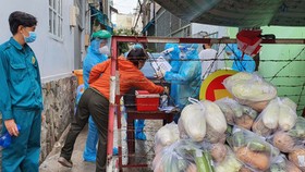 Lực lượng dân quân hỗ trợ chuyển lương thực giúp người dân ở quận Gò Vấp vào chiều 2-6 Ảnh: VĂN MINH