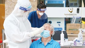 Nhân viên y tế Bệnh viện Đa khoa Quốc tế Nam Sài Gòn lấy mẫu xét nghiệm cho người dân. Ảnh: HOÀNG HÙNG