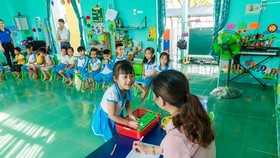 Các em học sinh trường Tiểu học thực hành thao tác gấp vỏ hộp sau khi uống sữa