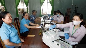 Một buổi làm thủ tục cho đối tượng chính sách vay vốn. (Ảnh: Trần Việt/TTXVN)