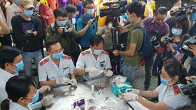 Ban quản lý an toàn thực phẩm TP.HCM lấy mẫu kiểm tra nhanh nhiều mặt hàng thực phẩm tại chợ Phạm Văn Hai - ẢNH: N.TRÍ