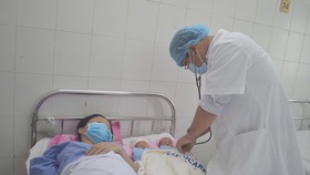 Bác sĩ chăm sóc cho sản phụ và 2 bé