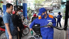 Nhân viên Petrolimex đang bán xăng cho khách hàng. (Ảnh: Đức Duy/Vietnam+)