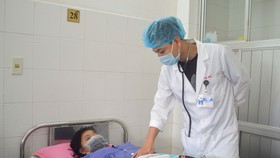 Bác sĩ chăm sóc cho bệnh nhân T. sau khi phẫu thuật thành công