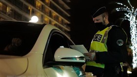 Cảnh sát kiểm tra giấy tờ của người lưu thông khi lệnh hạn chế được ban hành nhằm ngăn dịch COVID-19 lây lan tại Nice, Pháp. (Ảnh: AFP/TTXVN)