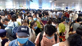 “Biển người” chen chúc trước cửa khu vực an ninh soi chiếu tại nhà ga quốc nội, sân bay Tân Sơn Nhất trưa 18-4 - Ảnh: DUYÊN PHAN