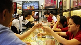 Khách hàng giao dịch vàng miếng. (Ảnh: TTXVN)