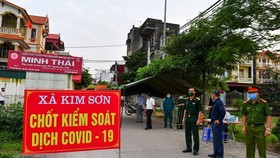 Lực lượng chức năng kiểm soát, cách ly y tế tại xã Kim Sơn, huyện Gia Lâm. (Ảnh: TTXVN phát)