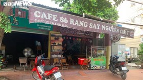 Một quán cà phê vắng bóng khách, chỉ có nhân viên phục vụ.