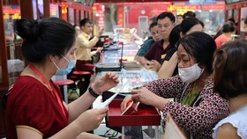Khách hàng giao dịch vàng miếng. (Ảnh: TTXVN)