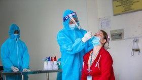 Cán bộ y tế test nhanh Covid-19 cho công nhân trên địa bàn Hậu Giang.