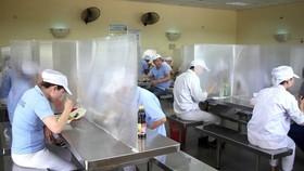 Nhà ăn của công nhân có vách ngăn, đảm bảo giãn cách. (Nguồn: TTXVN)