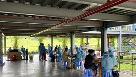 Tiêm vaccine phòng COVID-19 cho công nhân làm việc tại Khu chế xuất Tân Thuận. (Ảnh: Thanh Vũ/TTXVN)