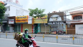 Nhiều doanh nghiệp ở TP.HCM chịu ảnh hưởng nặng nề bởi giãn cách xã hội. Trong ảnh là các cửa hàng tại quận 7 đang đóng cửa (ảnh chụp ngày 16-9) - Ảnh: BÔNG MAI