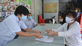 Phát tiền hỗ trợ đợt 2 cho người bị thất nghiệp ở phường 15, quận 10, TP.HCM - Ảnh: TỰ TRUNG