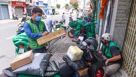 Shipper lấy hàng trên đường Nguyễn Kiệm, quận Phú Nhuận (TP.HCM) để giao cho khách vào sáng 20-9 - Ảnh: QUANG ĐỊNH