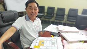 Ông Huỳnh Uy Dũng bên sơ đồ vị trí 255 lô đất nền muốn tặng