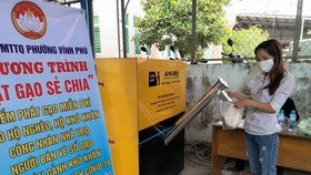 Người dân nhận gạo hỗ trợ từ chương trình ATM gạo ở phường Vĩnh Phú, TP Thuận An