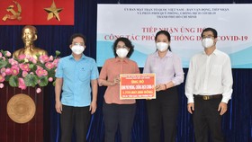 Chủ tịch Ủy ban MTTQ Việt Nam TPHCM Tô Thị Bích Châu tiếp nhận bảng tượng trưng ủng hộ từ Đảng ủy Khối Dân - Chính - Đảng TPHCM.