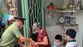 Thiếu tướng Cao Đăng Hưng trao quà tận tay người dân có hoàn cảnh khó khăn ở phường 8, quận 4, TPHCM. Ảnh: CHÍ THẠCH