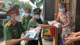 Thượng Tá Trần Anh Thanh, Phó Trưởng Phòng PX03, Công an TPHCM cùng Thượng tá Huỳnh Trung Phong, Trưởng Công an quận 6 gõ cửa nhà dân trao các phần quà hỗ trợ. Ảnh: CHÍ THẠCH