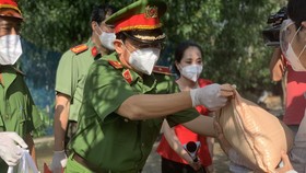 Công an TPHCM trao quà cho người dân ở khu phong tỏa quận Bình Thạnh. Ảnh: C.T
