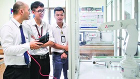 Students of the automation major in their practice lesson to control robots. (Photo: SGGP)