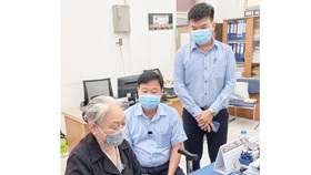 77-year-old Nguyen Thi Thao from District 5 is giving the money to the vaccine fund. (Photo: The Vietnam Fatherland Front Committee of District 5)