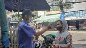 Từ 6 giờ sáng 9-5, Ban quản lý chợ Đống Đa bố trí 3 cổng vào chợ với đầy đủ lực lượng bảo vệ, triển khai yêu cầu người dân trình phiếu đi chợ, sát khuẩn và đeo khẩu trang trước khi vào