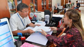 Công chức tận tình, chu đáo với người dân làm thủ tục hành chính tại UBND quận 4, TPHCM. Ảnh: VIỆT DŨNG