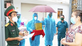 Các chiến sĩ lực lượng vũ trang TPHCM đưa tro cốt của người đã khuất vì dịch Covid-19 đến tận tay người thân tại địa bàn quận 8. Ảnh: HOÀNG HÙNG