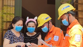 Nhân viên EVNHCMC hướng dẫn người dân sử dụng tiện ích số trong quản lý, tiêu dùng điện
