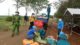 Lực lượng chức năng hỗ trợ đồng bào dân tộc thiểu số ở huyện Bù Gia Mập.