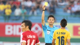Trọng tài Sato Ryuji rút thẻ vàng với cầu thủ Thanh Hóa tại V-League 2014. Ảnh: QUANG LIÊM