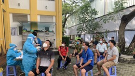 Nhân viên y tế tiến hành lấy mẫu xét nghiệm Covid-19 cho thành phần tham dự Giải futsal VĐQG 2021. Ảnh: ANH TRẦN