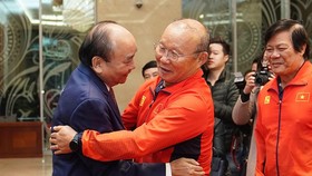 Thủ tướng Nguyễn Xuân Phúc chúc mừng HLV Park Hang-seo tại buổi gặp mặt 2 đội tuyển bóng đá nam và nữ vừa từ Philippines trở về tối 11-12. Ảnh: MINH HOÀNG