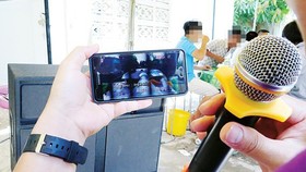 A set of portable Bluetooth speakers, microphones, and a cell phone is enough to setup a home karaoke. (Photo: SGGP)