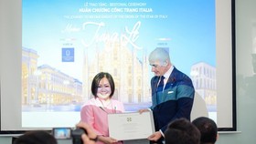 Consul General of Italy in HCMC presents the title of Knight of the Order of Star of Italy to Chairwoman of the Vietnam International Fashion Week (VIFW), Le Thi Quynh Trang. (Photo: SGGP)