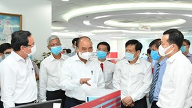 President Nguyen Xuan Phuc (C) and Secretary of the Party Committee of HCMC Nguyen Van Nen (L) visit the SGGP Newspaper. (Photo: SGGP)