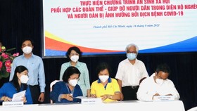 Chairwoman of Vietnam Fatherland Front Committee in Ho Chi Minh City To Thi Bich Chau (C, standing) cum director of the HCMC Social Security Center attends the signing ceremony. (Photo: SGGP)