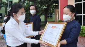 Vice Chairwoman of the HCMC Chapter of the Vietnam Fatherland Front Phan Kieu Thanh Huong presents certificates of merit to religious volunteers. (Photo: SGGP)