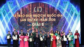 State President Nguyen Xuan Phuc (R) and Politburo member Vo Van Thuong, Permanent member of the Party Central Committee's Secretariat present award to the Nhan Dan (People) Newspaper.