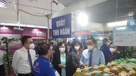 Vice Chairwoman of the HCMC People’s Committee Phan Thi Thang (C) visits a display booth in the conference. (Photo: SGGP)