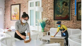 The staff of Phuong Cac coffee shop clean tables before opening.