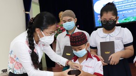 Phó Chủ tịch Ủy ban MTTQ Việt Nam TPHCM Phan Kiều Thanh Hương trao máy tính bảng cho học sinh dân tộc thiểu số
