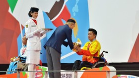 VĐV Nguyễn Thành Trung đón nhận tấm HCV 100m ếch nam.