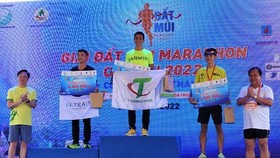 Phó Chủ tịch UBND tỉnh Nguyễn Minh Luân (bìa trái) và đại diện lãnh đạo Tập đoàn PetroVietNam trao giải cho các vận động viên xuất sắc nhất cự ly 42 km nội dung nam. ẢNH: TRÚC ĐÀO