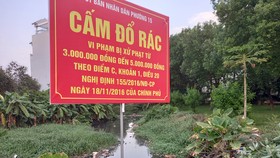 Một con rạch ở phường 15 (quận Gò Vấp) bị người dân quăng rác dày đặc, gây tắc nghẽn dòng chảy và bốc mùi hôi thối, dù có biển cấm đổ rác của UBND phường. Ảnh: Đức Trung